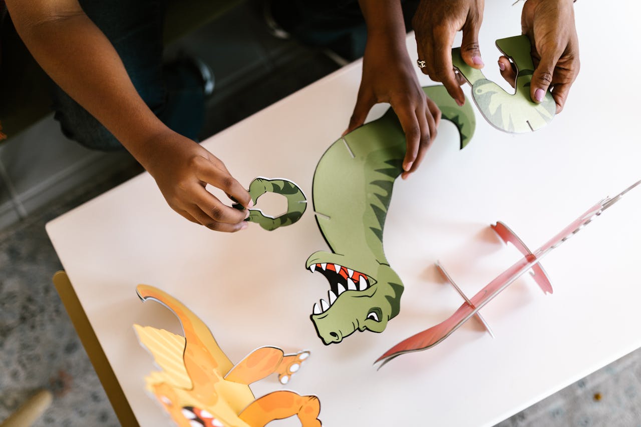 pexels-photo-7605993 Children engage in creative learning by assembling a dinosaur puzzle, fostering teamwork.